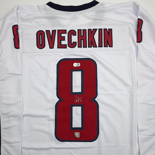 Back view of white hockey jersey displaying "OVECHKIN" nameplate and red number 8 with signature.