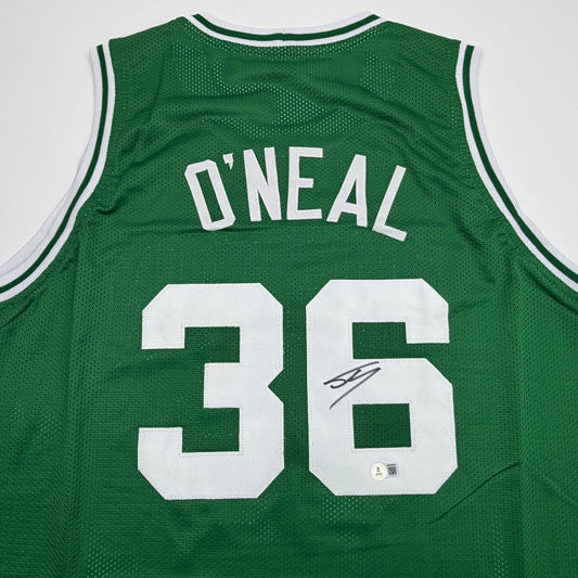 Back view of green Celtics jersey with "O'NEAL" and number "36" in white, featuring autographed signature and authentication sticker.