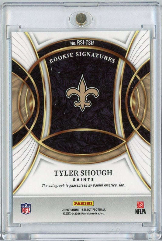 Back of 2025 Panini Select Tyler Shough Saints rookie autograph card with fleur-de-lis logo, gold trim, and black background in plastic case.