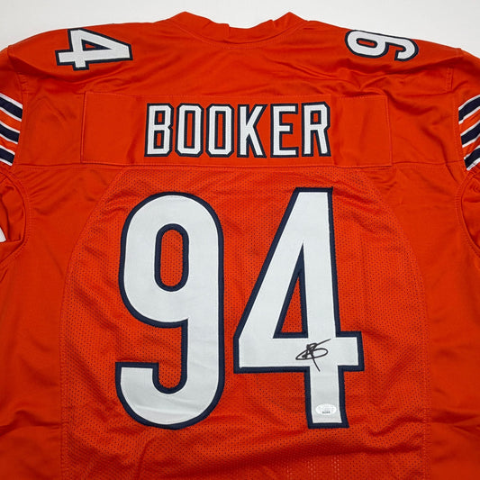 Back view of signed orange Chicago pro cut football jersey displaying "BOOKER" and number "94" in white with navy trim.