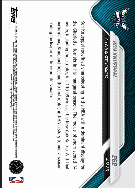Front of basketball trading card showing Kon Knueppel rookie card with orange foil border and Charlotte Hornets logo against teal striped background.