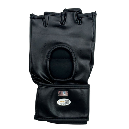 Black leather UFC MMA fighting glove displayed flat, showing open palm side with finger hole and JSA authentication label.