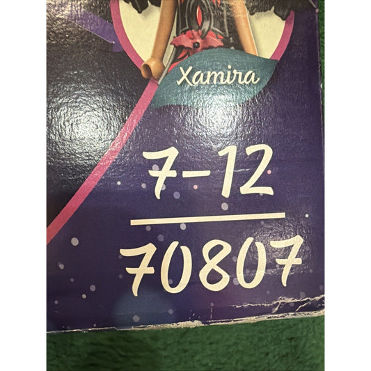 Close-up of Playmobil 70807 box front showing "Xamira" name, product numbers 7-12 and 70807, with purple background and illustrated fairy character.