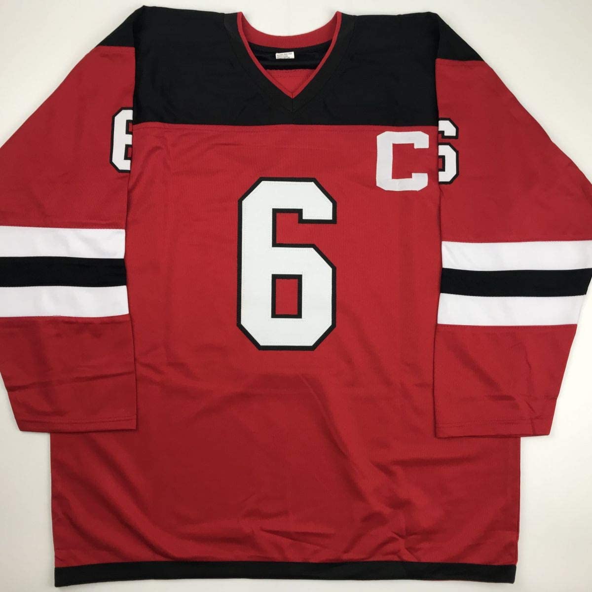 Red hockey jersey with black and white horizontal stripes on sleeves, white number 6 on chest, displayed flat against white background.