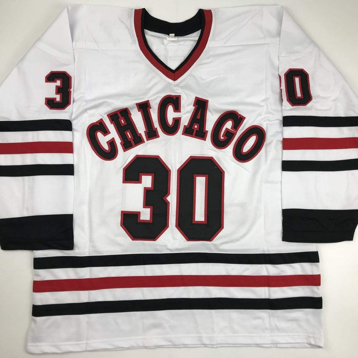 White Chicago hockey jersey with red and black striped sleeves, displaying "CHICAGO" and number 30 across the chest, laid flat against a neutral background.