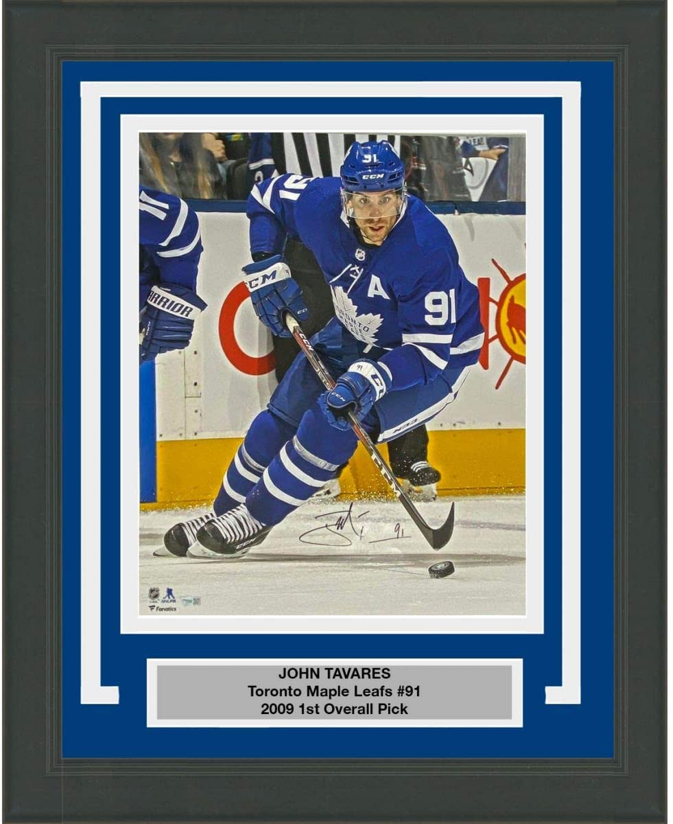 Signed photo of John Tavares in Toronto Maple Leafs blue jersey number 91 skating with hockey stick, mounted in blue and white matting with nameplate.