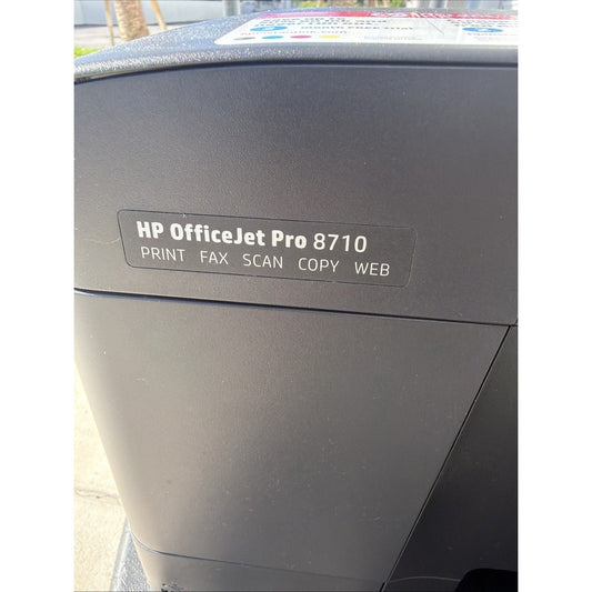 Close-up front view of dark gray HP OfficeJet Pro 8710 printer showing model name and function labels for print, fax, scan, copy, and web.