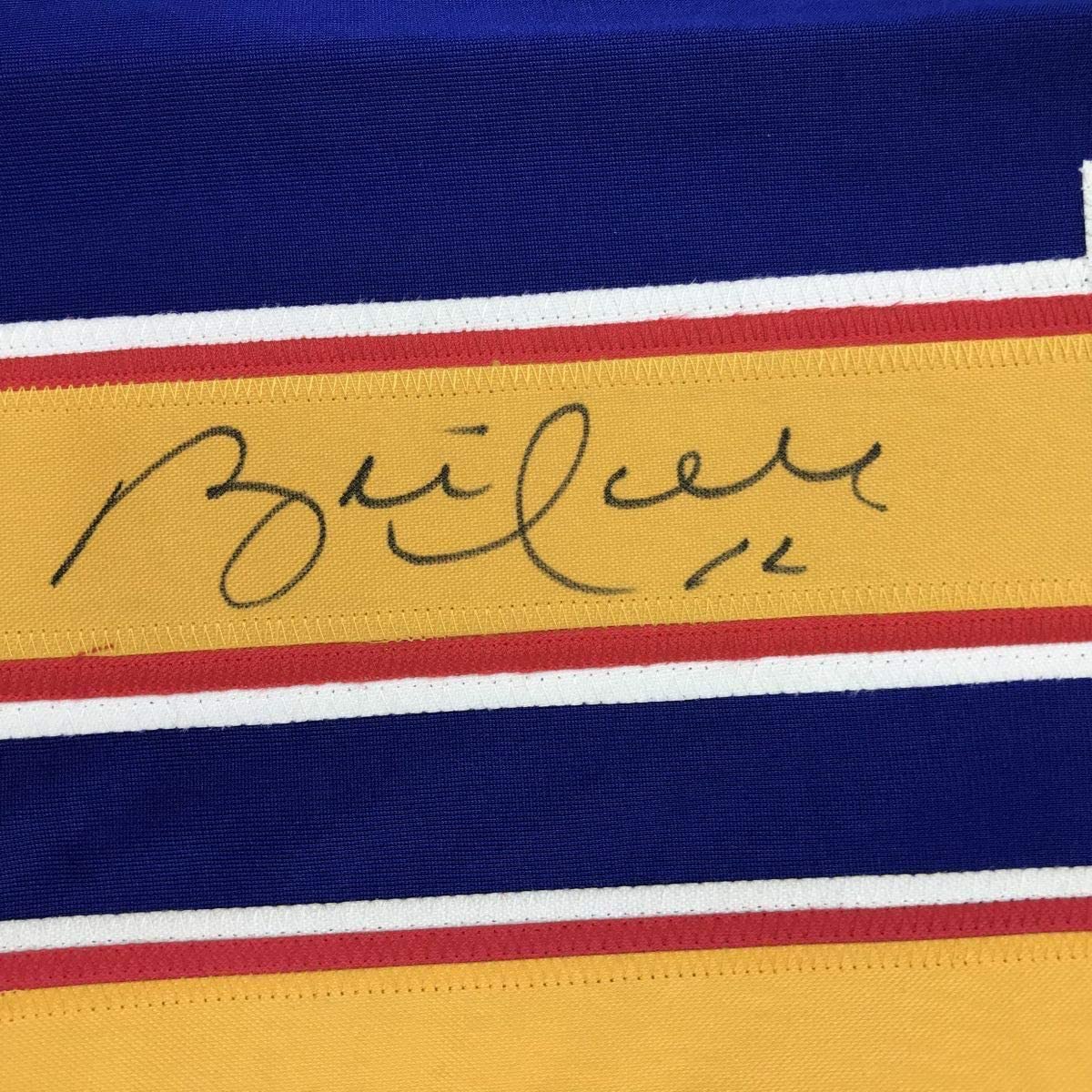Close-up of Brett Hull's handwritten signature on yellow stripe of blue, white, and red striped hockey jersey.