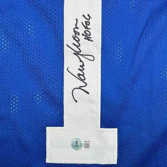Close-up of white nameplate on blue mesh jersey with handwritten "Warren Moon" signature and authentication hologram label.