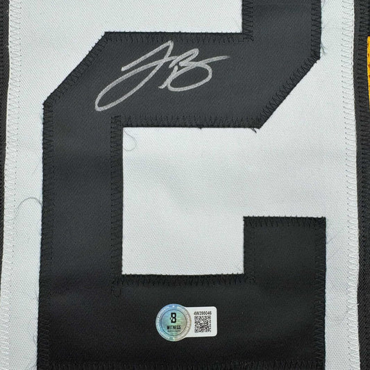 Close-up of signed Pittsburgh Steelers black and white jersey with authentication hologram and QR code visible.