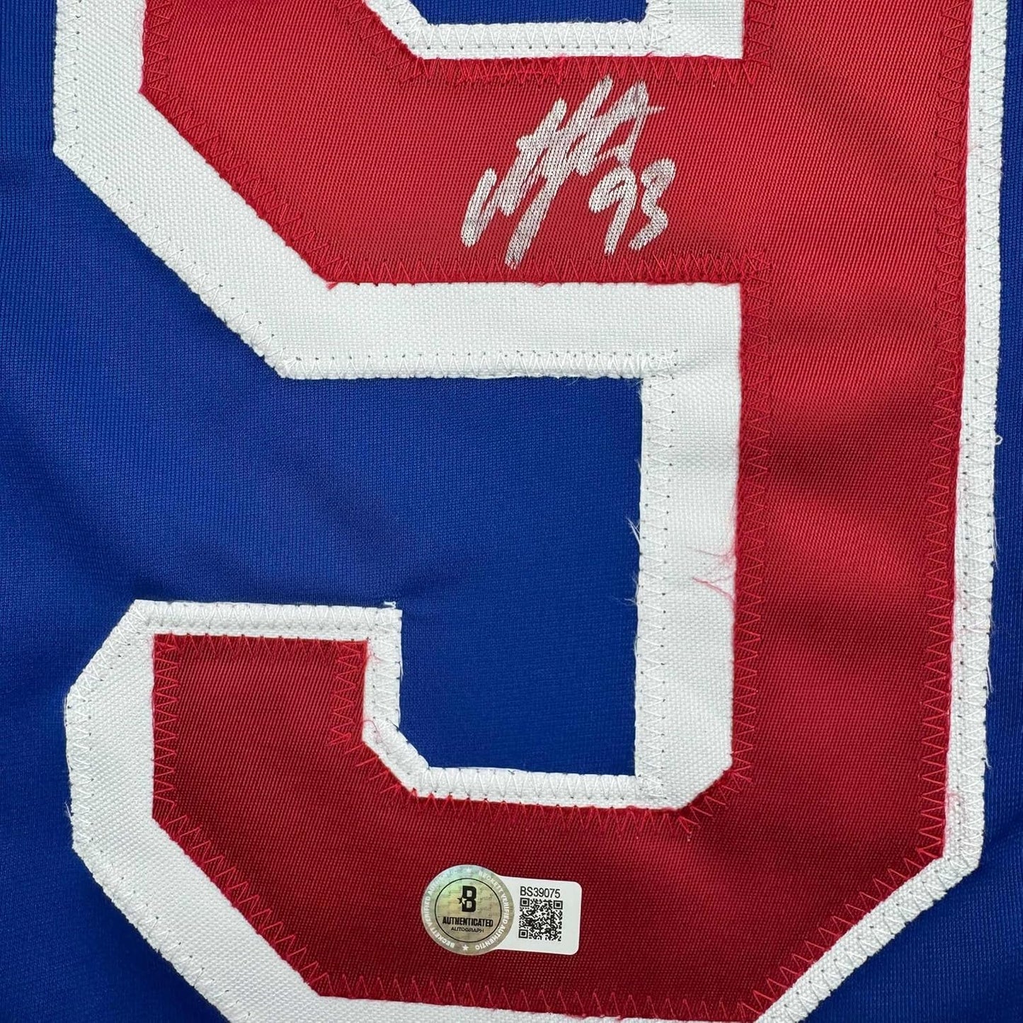 Close-up of signed red and blue New York Rangers hockey jersey number 93 with Beckett authentication hologram visible at bottom.