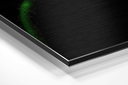 Angled perspective view of layered Dibond panel showing brushed black surface with green wilting flower detail and white backing layer.
