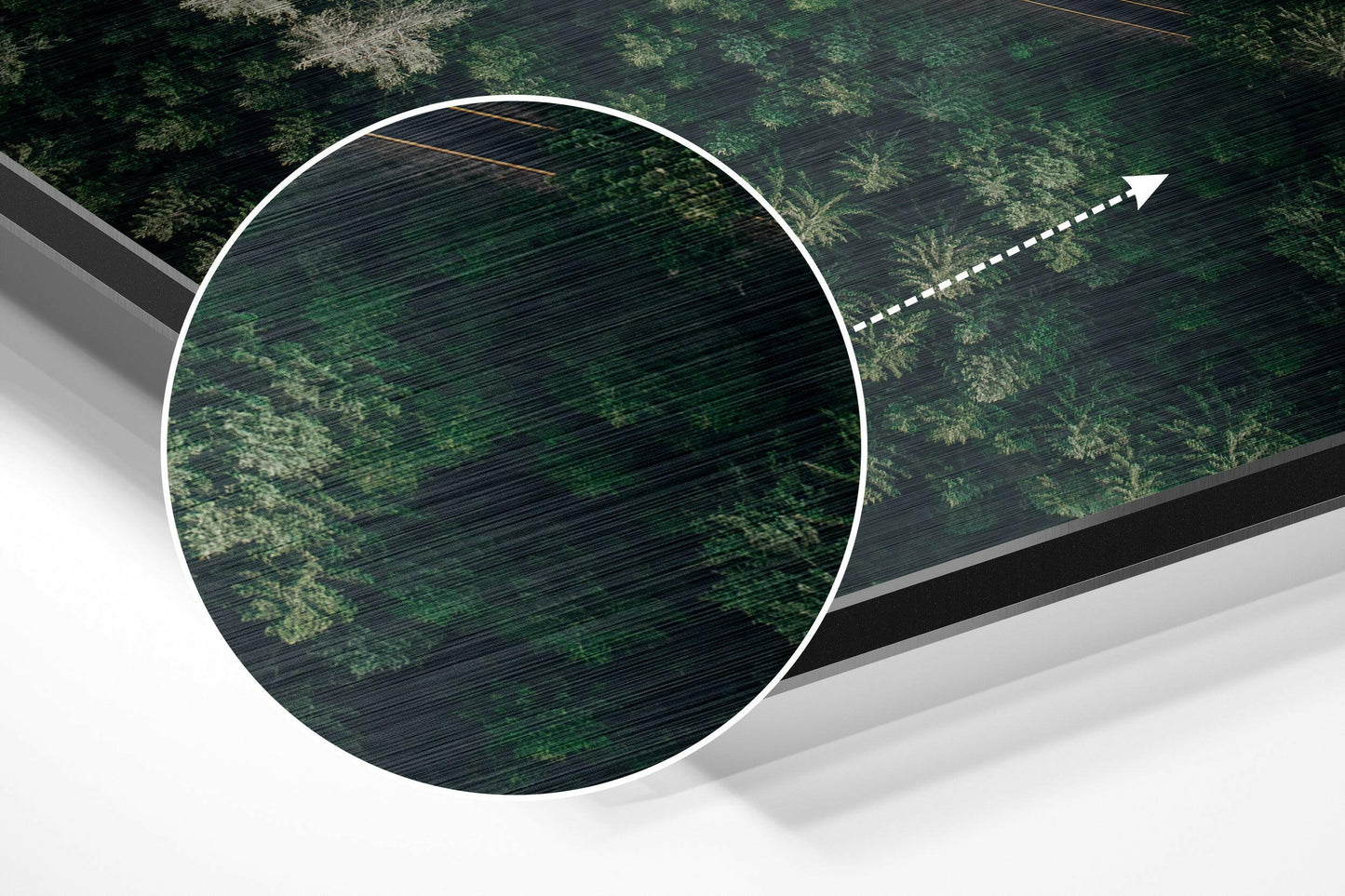 Overhead perspective of circular brushed aluminum wall art mounted on green forest canopy with directional arrow overlay.