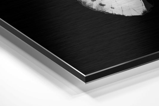 Close-up angled view of layered black brushed aluminum and white composite panels with white butterfly detail visible at top edge.