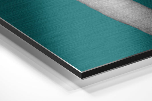 Close-up angled view of layered aluminum dibond panel showing teal brushed metal surface with white and gray backing layers.