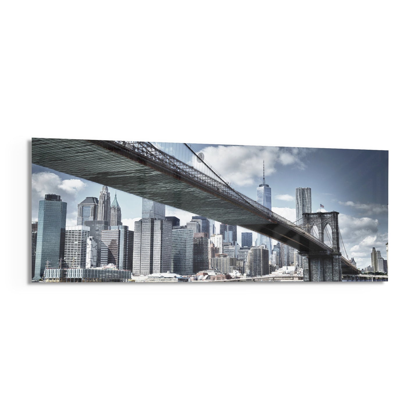 Brooklyn Bridge framed glass panel displaying Manhattan skyline viewed from beneath the bridge, featuring skyscrapers and cloudy sky.