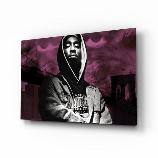 Black and white photograph of a hooded figure wearing a Raiders shirt against a purple-tinted urban bridge background, displayed as glass wall art.