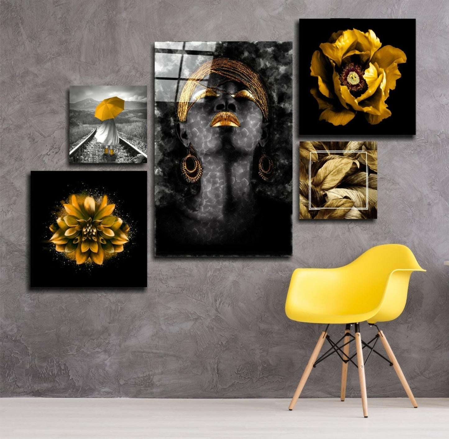 Gallery wall display of five glass art panels featuring black and white portraits with gold accents and yellow flowers, arranged above a yellow modern chair.