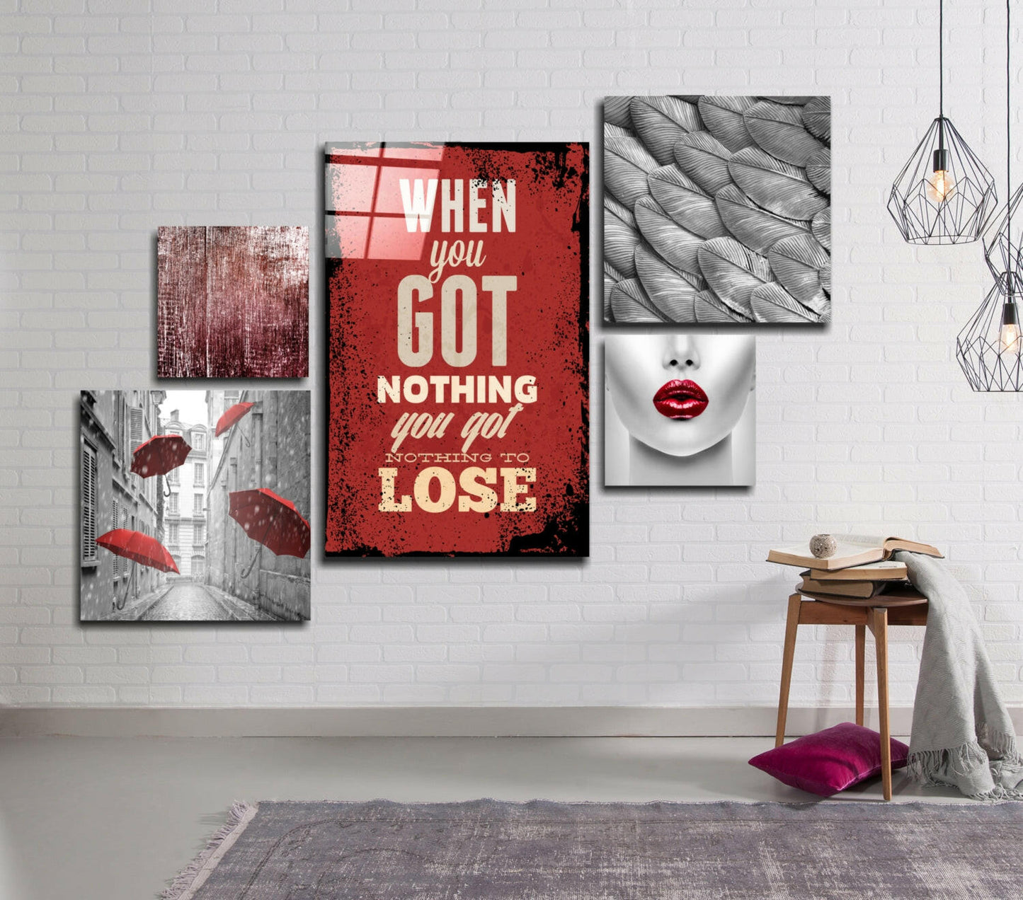 Five glass wall art panels arranged on white brick wall featuring red motivational text, grayscale street umbrellas, textured patterns, and red lips portrait.
