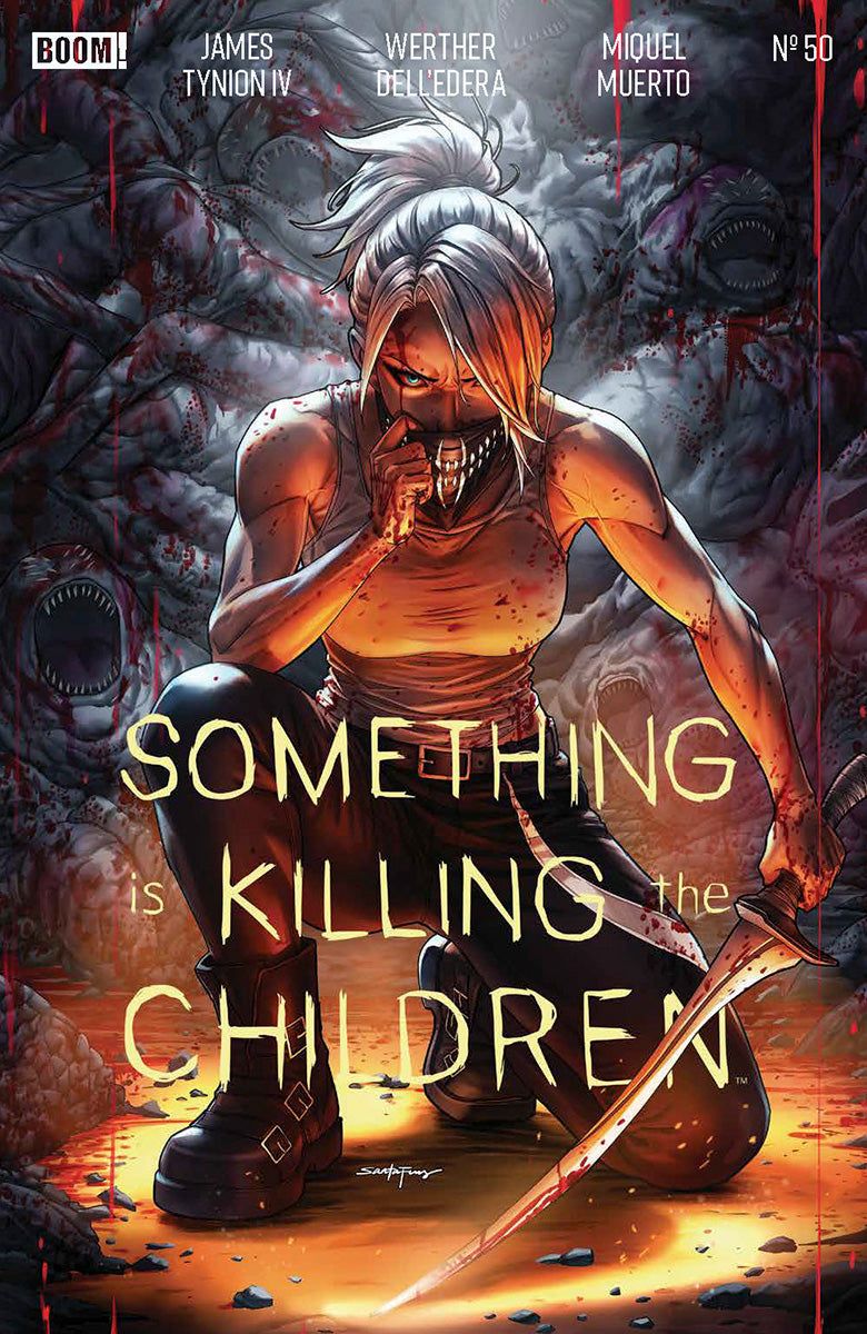 Front cover of a comic showing a white-haired woman kneeling with a bloody knife, yellow title lettering, and a BOOM! logo.
