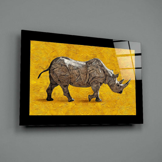 Black-framed glass wall art displaying a detailed brown rhino against a vibrant yellow textured background, mounted at an angle on gray wall.