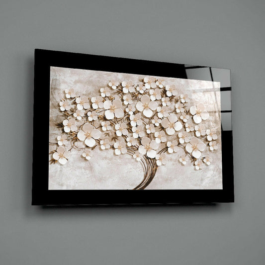 Black-framed glass wall art displaying a white flower tree with cream petals against a textured beige background, mounted on a gray wall.