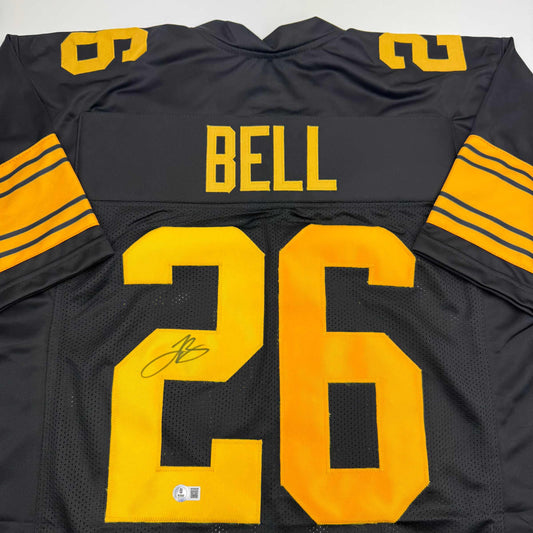 Back view of black Pittsburgh Steelers Color Rush jersey number 26 with "BELL" nameplate and autographed signature on yellow numbers.