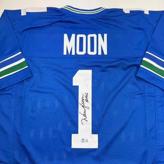 Blue Seattle Seahawks jersey number 1 with "MOON" nameplate and autographed signature on white number, flat lay back view.