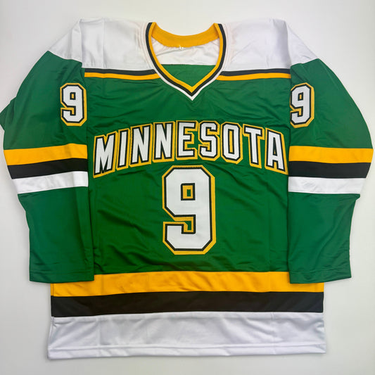 Green Minnesota hockey jersey number 9 with gold and white trim displayed flat against white background, front view.
