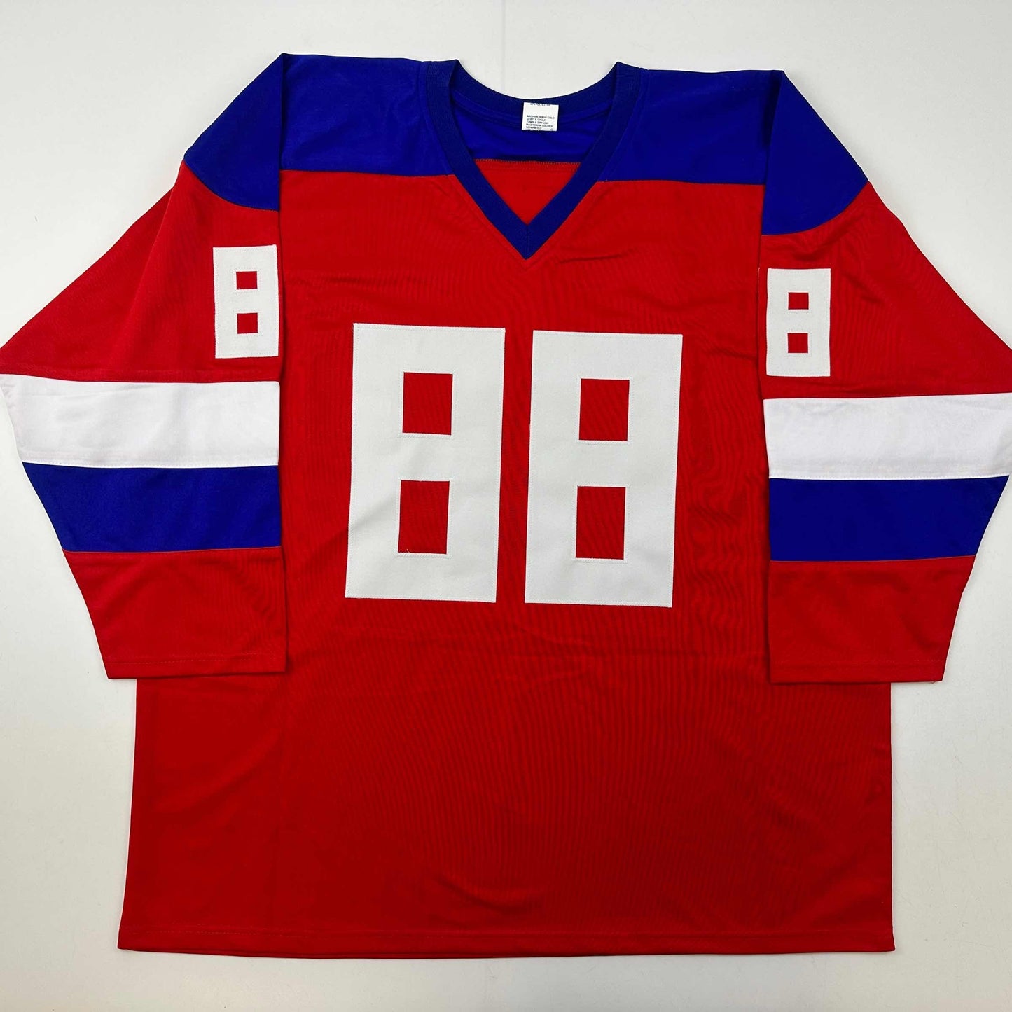 Red Team Russia Olympics hockey jersey with blue shoulders, white number 88, and white side stripes, displayed flat on white background.