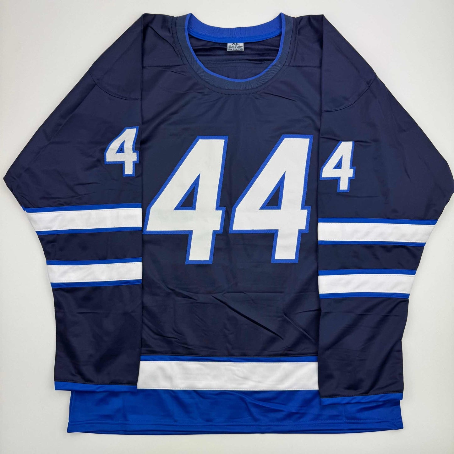 Navy blue hockey jersey with white and blue horizontal stripes, large white number 44 on front, displayed flat against white background.