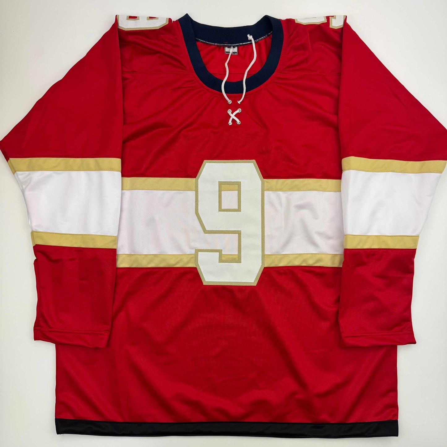 Red hockey jersey with white and gold horizontal stripes, number 9, displayed flat against white background.