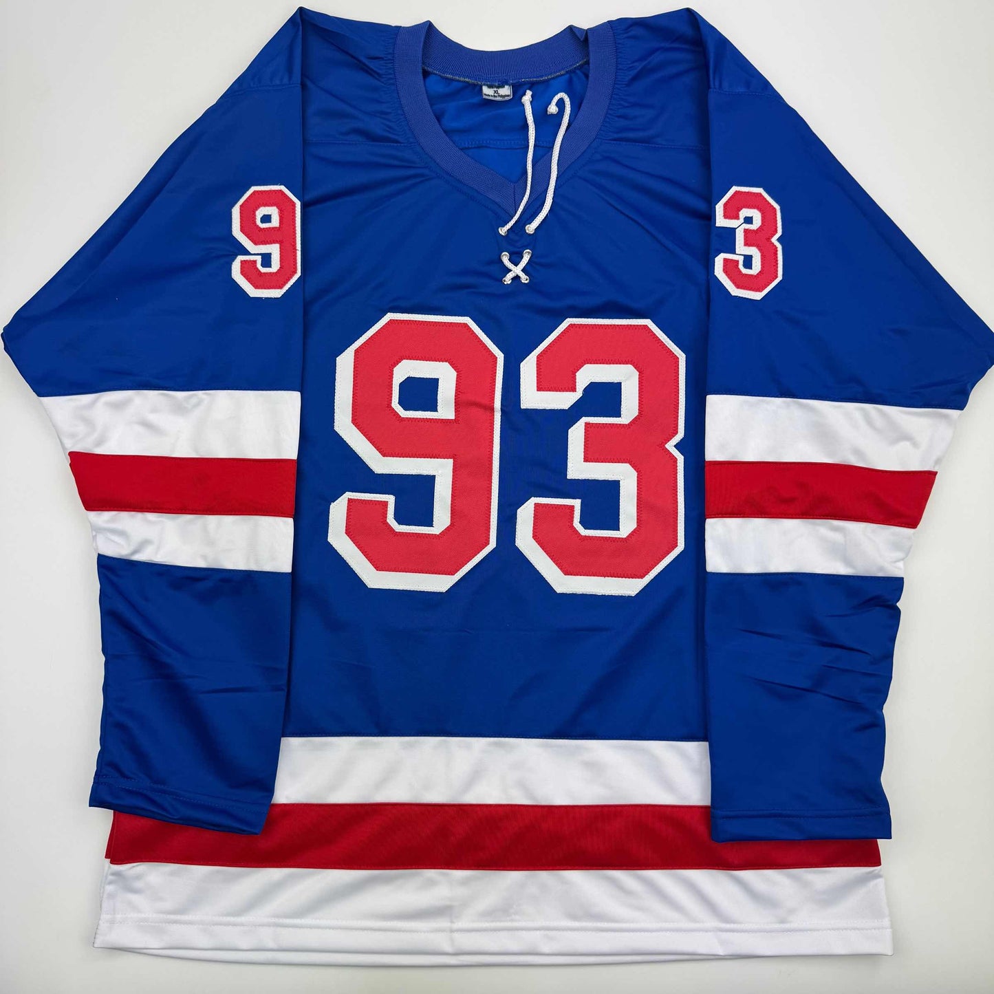 Blue, white, and red striped hockey jersey with large red number 93 and smaller numbers 9 and 3 on shoulders, displayed flat against white background.
