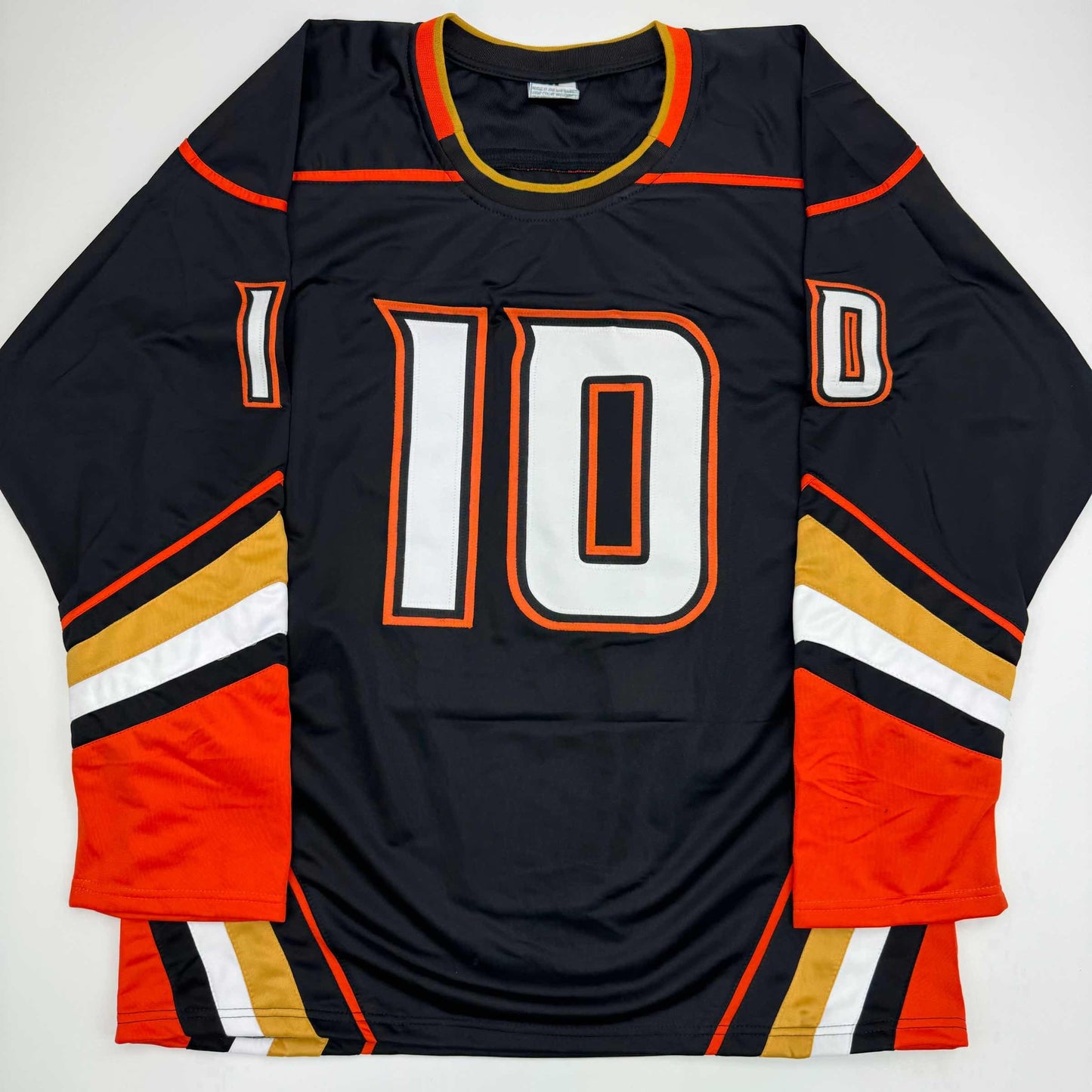 Black hockey jersey number 10 with orange and gold trim displayed flat against white background, front view.