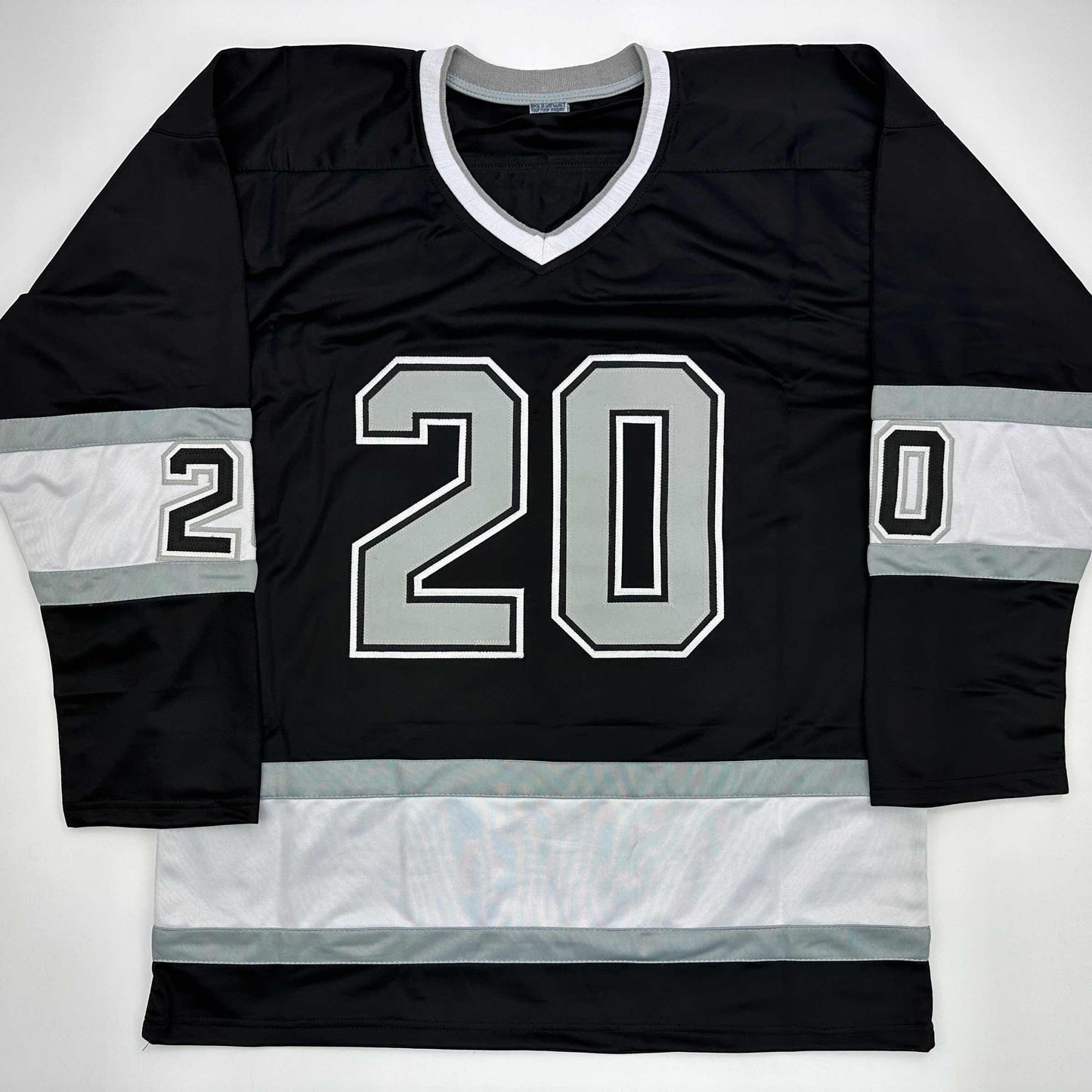 Black and white striped hockey jersey with number 20 displayed flat on white background, front view.