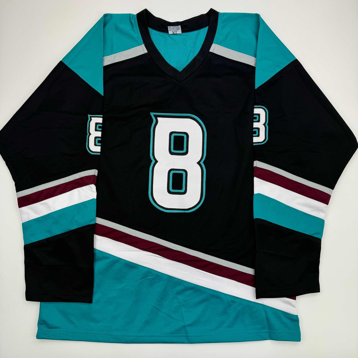 Black and teal hockey jersey with number 8 displayed flat against white background, showing front design with striped sleeves and shoulders.