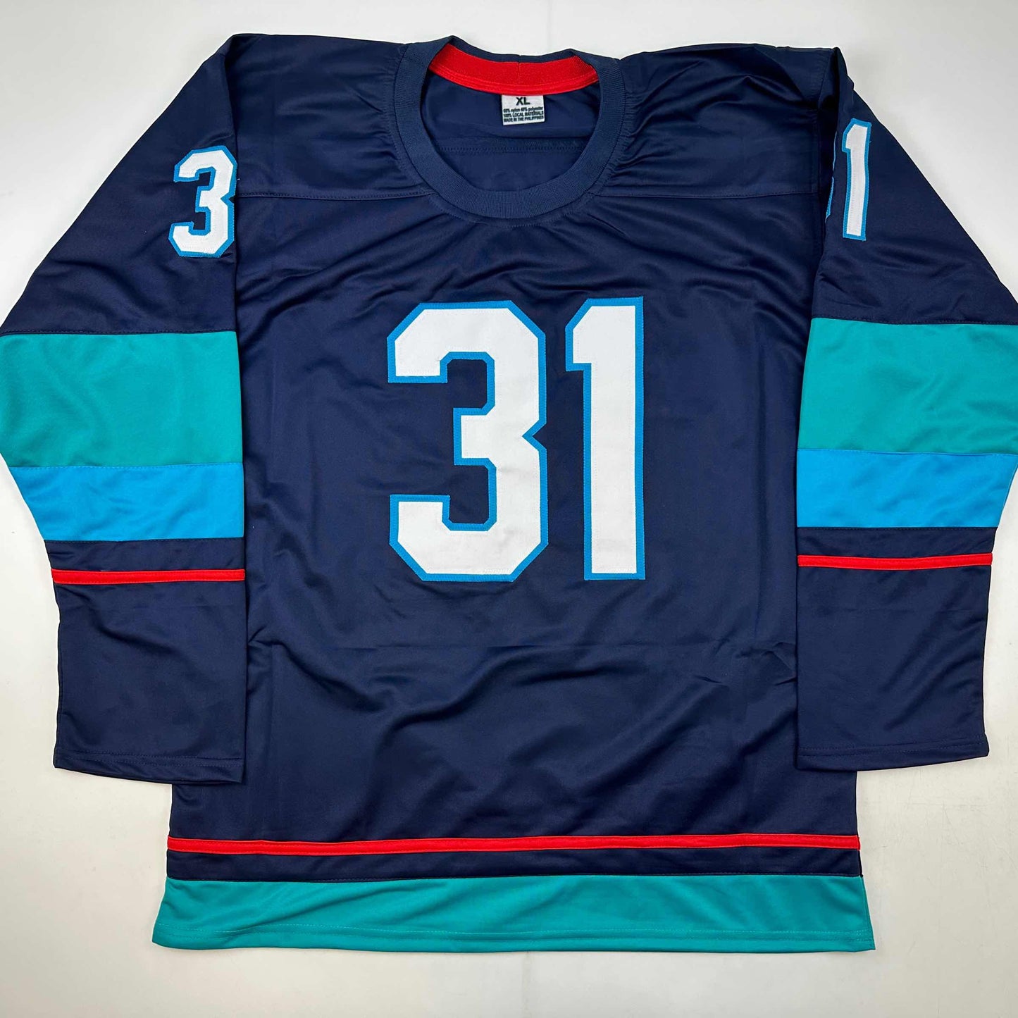 Navy blue hockey jersey number 31 with cyan and red striping, displayed flat lay from front view.