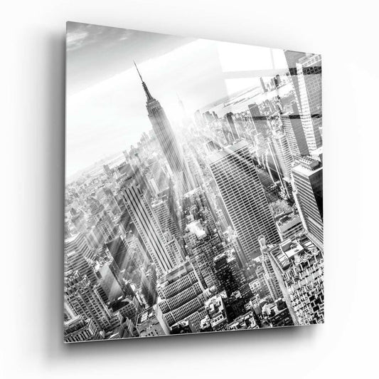 Black and white aerial photograph of Manhattan skyline on glass wall art panel, showing Empire State Building and surrounding skyscrapers from above.