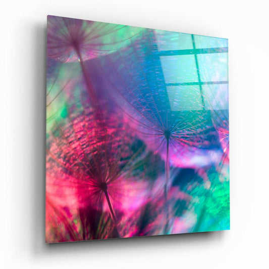 Angled perspective of glass wall art displaying vibrant pink, teal, and purple dandelion seeds with grid pattern overlay.