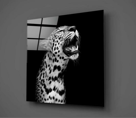 Black and white glass wall art displaying a roaring leopard in profile against dark background, mounted on gray wall.