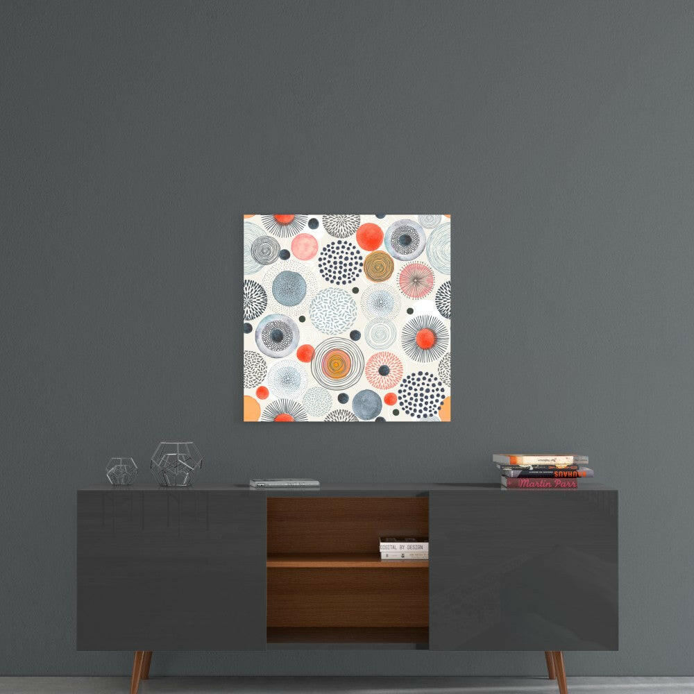Square glass wall art with geometric circular patterns in orange, blue, gray, and white tones displayed above mid-century modern credenza.