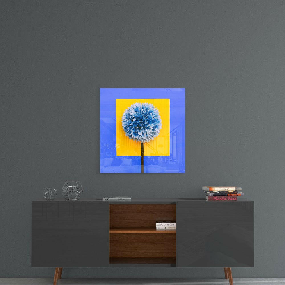 Blue and yellow glass wall art featuring a blue spherical dandelion flower displayed above a mid-century modern credenza.