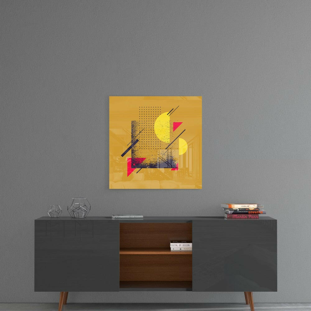 Yellow glass wall art with geometric shapes in pink, yellow, and black mounted above a dark mid-century modern credenza.