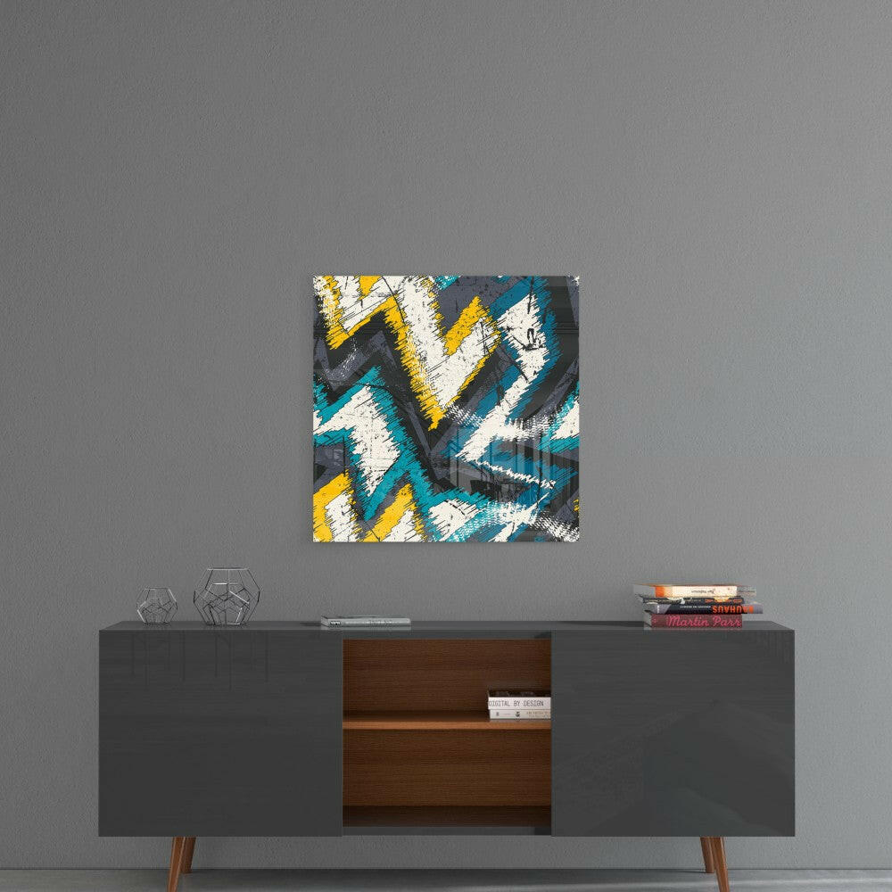 Abstract geometric glass art with blue, yellow, white, and gray chevron pattern hanging above mid-century modern credenza.