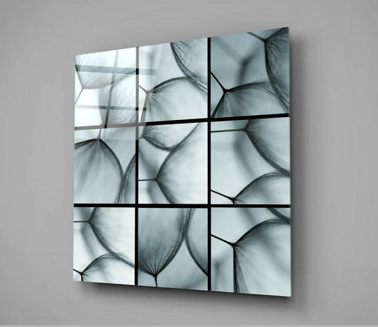 Nine-panel glass wall art featuring translucent dandelion seed heads in grayscale, mounted at an angle against a neutral background.