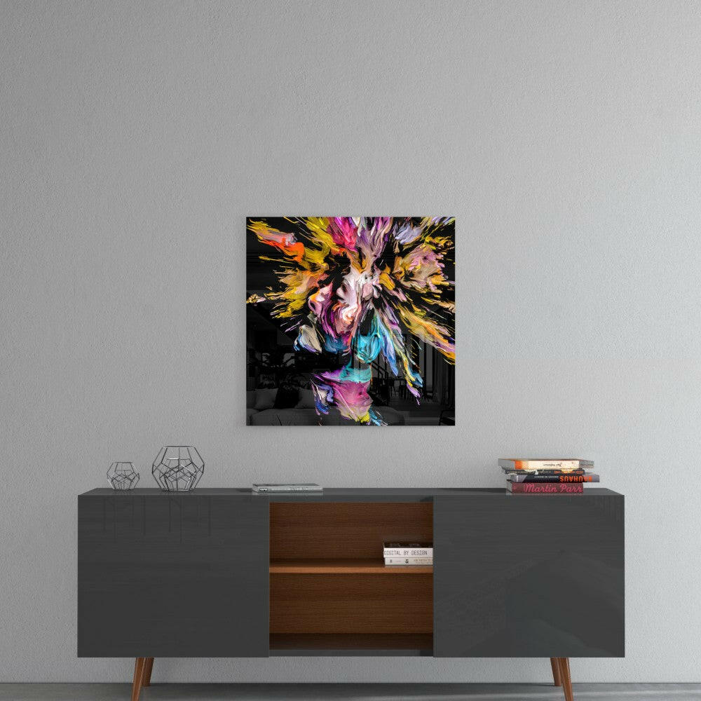 Colorful abstract glass wall art with vibrant yellow, pink, and blue paint splatters on black background, displayed above mid-century modern credenza.