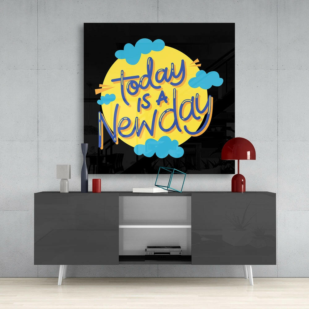 Colorful glass wall art with yellow sun, blue clouds, and purple text reading "Today is a New Day" displayed above a gray media console.