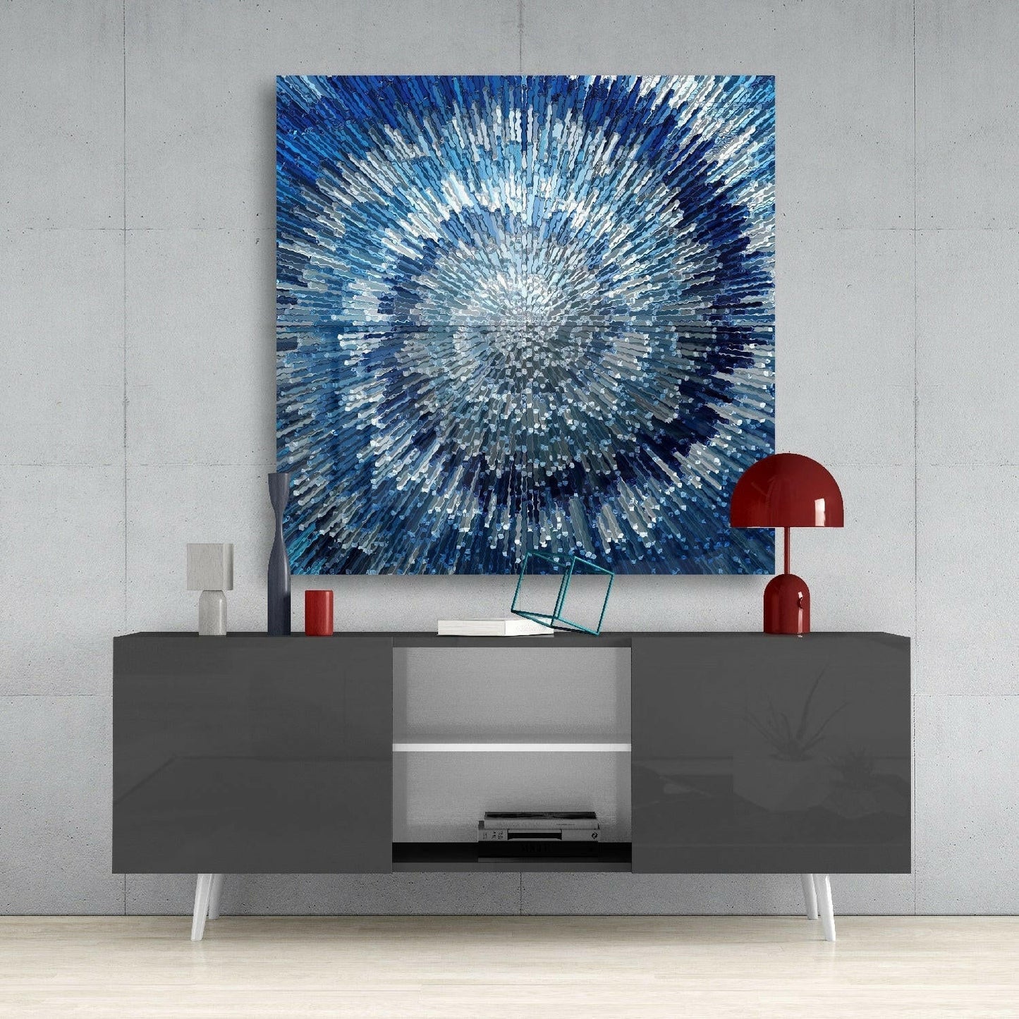 Blue and white radial glass wall art displayed above a dark gray media console with red accents in a minimalist interior.