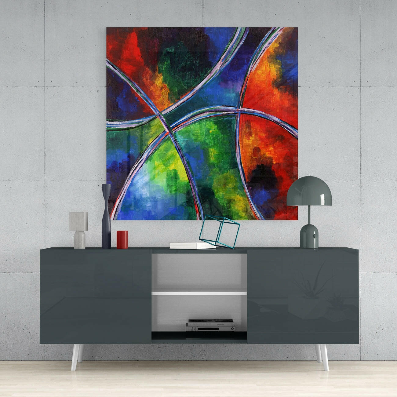 Colorful abstract glass wall art with red, blue, green, and orange sections divided by silver curves, displayed above a dark grey media console.