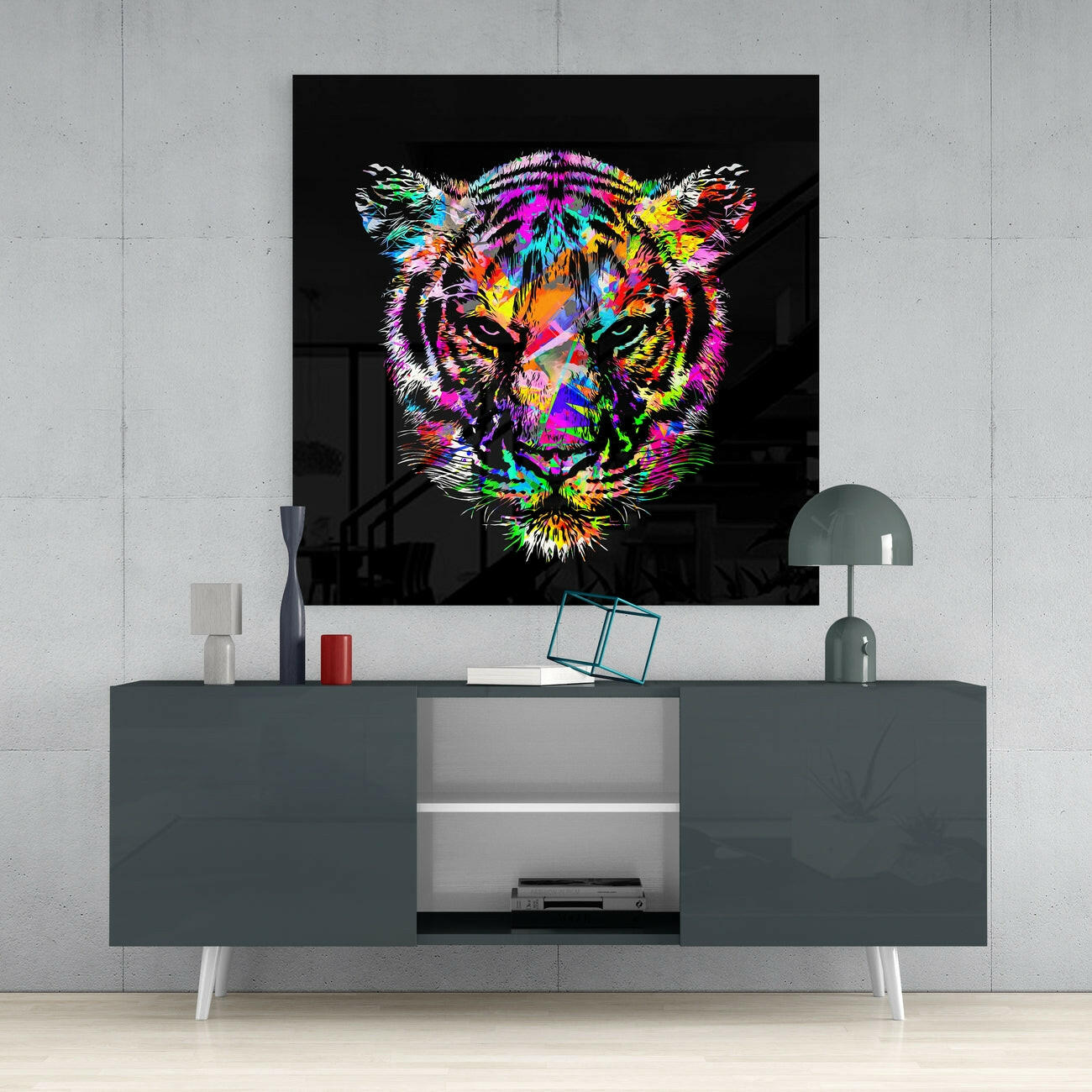 Vibrant multicolored tiger head artwork displayed on black glass mounted above a dark gray media console in a modern interior setting.